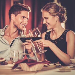 Cheerful couple in a restaurant with glasses of red wine